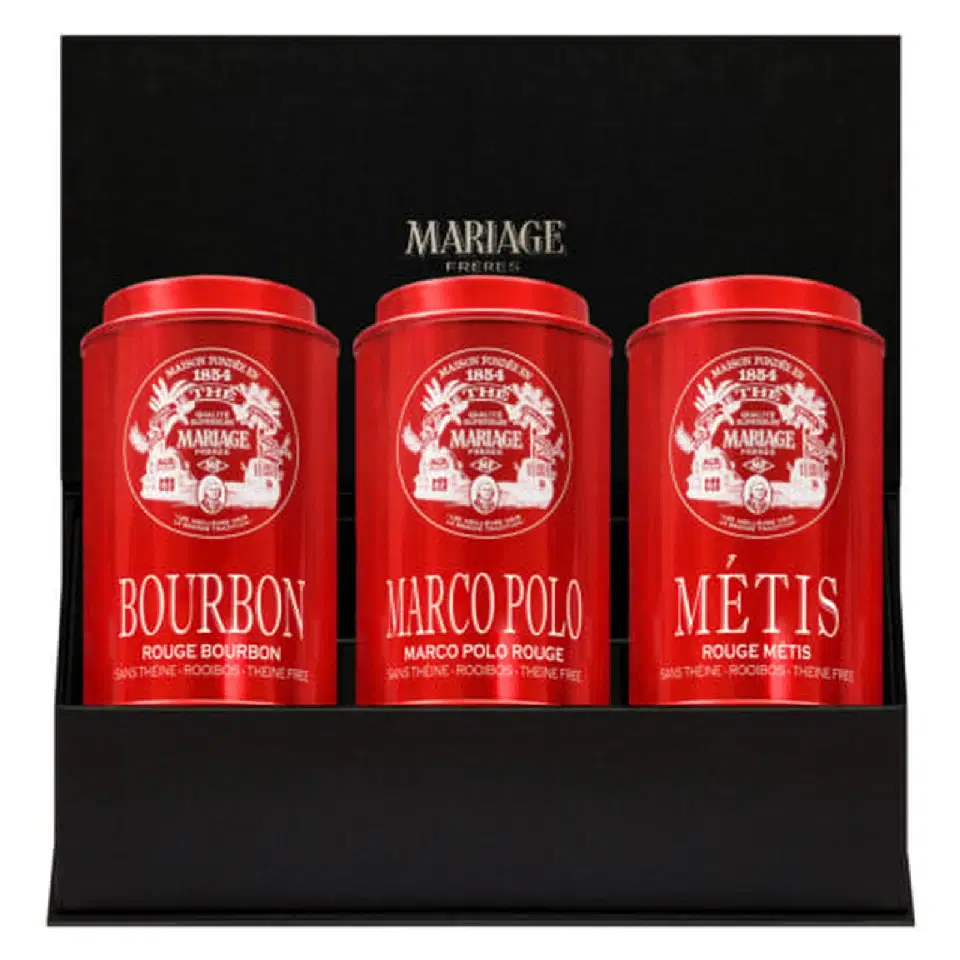Trois boîtes rouges Rouge Bourbon, Marco Polo Rouge et Rouge Métis dans un écrin noir