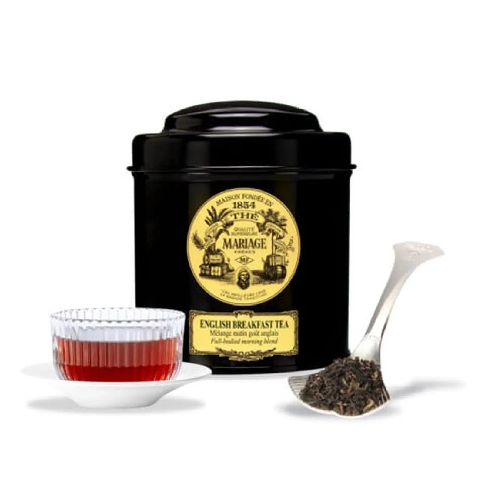 Boîte noire d'English Breakfast Mariage Frères à côté d'une tasse de thé rouge ambré et d'une cuillère de feuilles