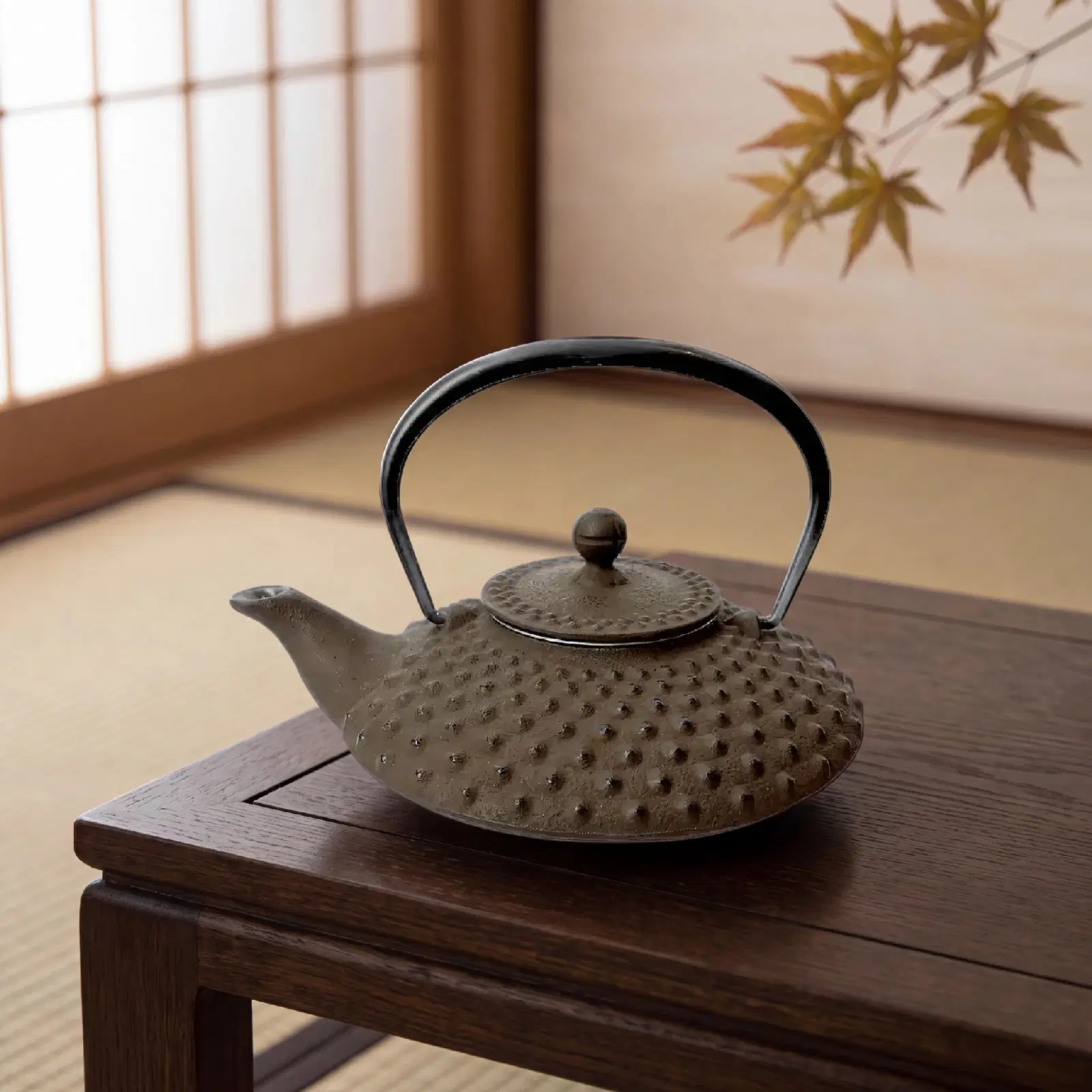 Théière Kanbin en fonte brune posée sur une table basse en bois, dans une pièce japonaise
